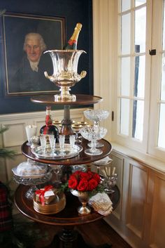 a three tiered tray with wine bottles and glasses on it