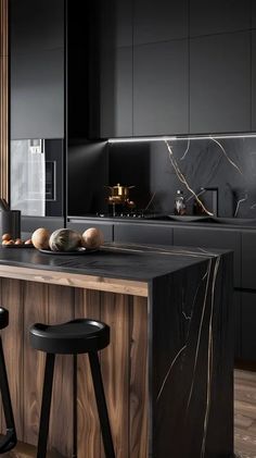 a black kitchen with marble counter tops and stools next to an island in the middle