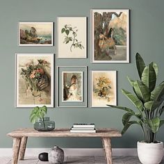 a living room with green walls and pictures hanging on the wall above a wooden table