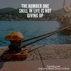 a yellow buoy sitting on top of a pier next to the ocean with a boat in the background