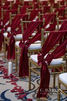 rows of chairs with red sashes and bows