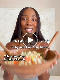 a woman is holding a bowl full of food and has the words high filter high protein salad