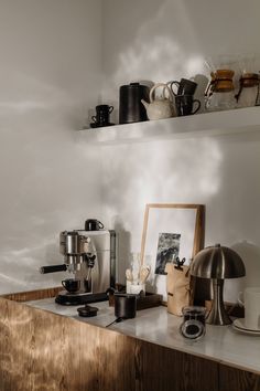 a kitchen counter topped with lots of pots and pans next to a coffee maker