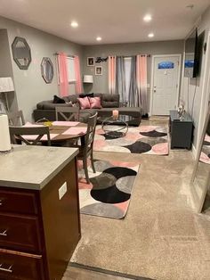 a living room filled with lots of furniture next to a kitchen and dining room table