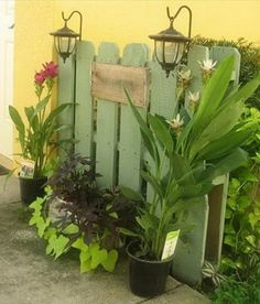 some potted plants are sitting in front of a fence