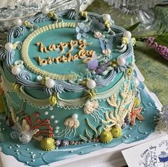 a blue birthday cake decorated with sea creatures and the words happy birthday written on it