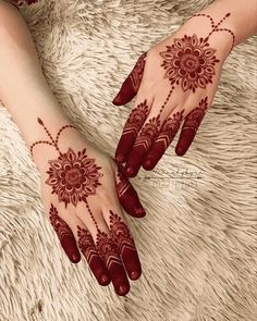 two hands with henna tattoos on them