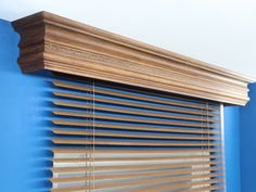 a wooden window with blue walls and wood blinds