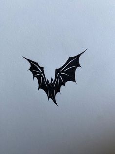 a bat flying through the air on top of a white sheet with black writing in it