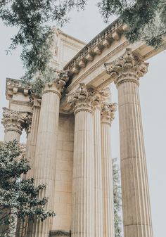 two people standing in front of some large pillars