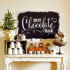 a sign that says hot chocolate bar next to a table with coffee cups and other items