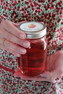 a woman holding a jar of jelly in her hands