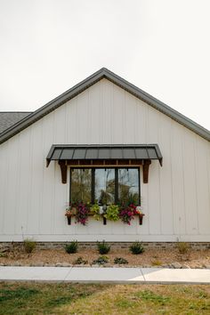 a white house with flowers in the windows