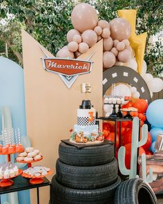 an assortment of desserts and balloons at a car themed birthday party