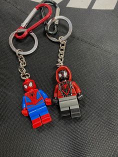 two lego key chains with spider - man on them