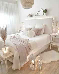 a bedroom with white walls, wooden floors and lots of lights on the headboard