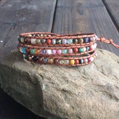 "This multi color gemstone wrap bracelet is so versatile. It is made with multi-gemstones woven on top quality natural red brown leather cord. It is accented throughout with glass beads for a little sparkle. This bracelet measures21\" to the first button closure. There are closures at 22\" and 23\". Custom sizes are available. Just send me a convo. If you like this bracelet you might also be interested in these. https://www.etsy.com/listing/263967656/leather-wrap-bracelet-beaded-wrap https://www Gemstone Wrap Bracelet, Beaded Wraps, Bracelet Beaded, Leather Wrap Bracelet, Bracelet For Women, Leather Wraps, Natural Red, Red Brown, Leather Cord