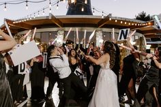 a bride and groom are surrounded by their guests on the dance floor at their wedding reception