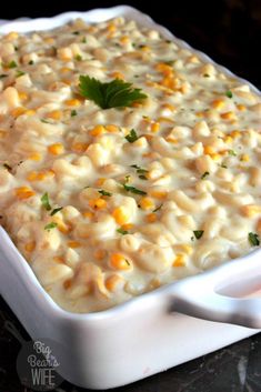 a casserole dish with macaroni and cheese, garnished with parsley