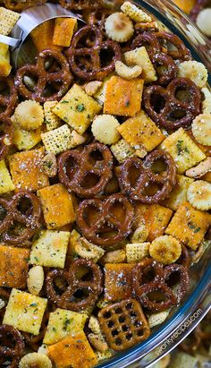 a bowl filled with cheetos and pretzels on top of crackers