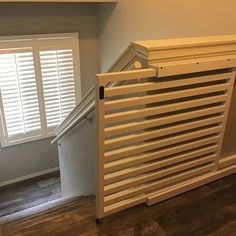 an empty room with white shutters and wood flooring