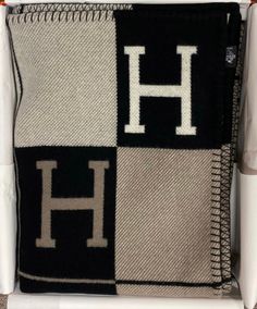 a black and white pillow with the letter h on it