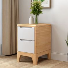 a plant is sitting on top of a white cabinet next to a potted plant