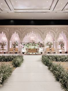 an indoor wedding setup with white flowers and greenery