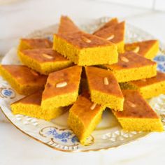 several pieces of cornbread on a plate next to a blue and white dish towel