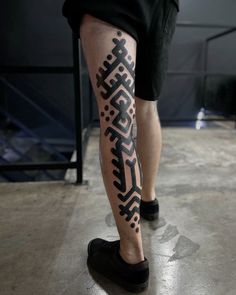 a man's legs with black and white tattoos on them