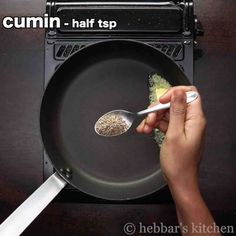 someone using a spoon to stir food in a frying pan with the words cumin - half sp on it