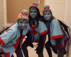 three people with painted faces and costumes posing for a photo in front of a mirror