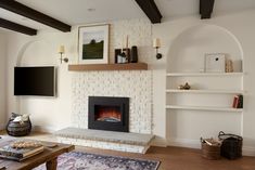 a living room filled with furniture and a flat screen tv mounted on a wall above a fire place