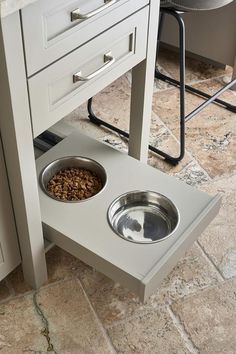 a dog is eating food out of its bowl on the floor next to some drawers