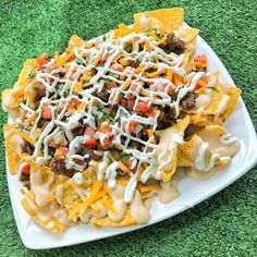 nachos with cheese and ground beef on a white plate