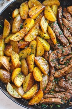 steak and potatoes in a skillet with herbs