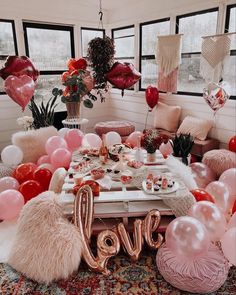 a table with balloons and letters on it in the middle of a room that is decorated for valentine's day