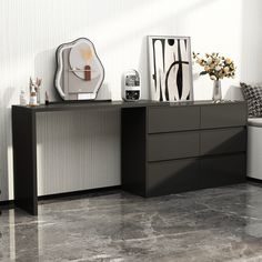 a black and white dresser sitting on top of a floor next to a wall mounted clock