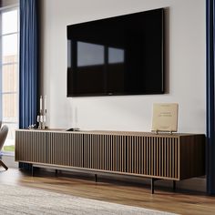 a flat screen tv mounted to the side of a wooden cabinet in a living room