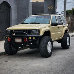 a beige suv parked in front of a building