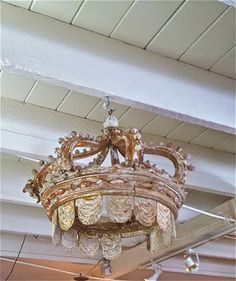 an ornate chandelier hangs from the ceiling in a room with white walls and ceilings