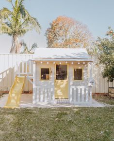 a small white house with a yellow slide