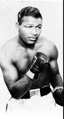 a black and white photo of a man wearing boxing gloves