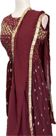 Step out in style with our Elegant Maroon Lehenga Choli, perfect for any special occasion. This beautiful ensemble is made from high-quality georgette fabric that is comfortable to wear, ensuring you look and feel amazing all day long. The sleeveless blouse features lovely mirror and embroidery work, adding a touch of glamour to the outfit. The flattering skirt is made of crushed fabric with layers and cancan inside, giving it the perfect amount of volume and movement. Suitable for parties, weddings, get-togethers, and all festive occasions, this stunning Lehenga Choli also makes a great gift. Complete with a matching dupatta, this outfit is sure to turn heads wherever you go.   Suitable for any festive occasions, weddings, parties, celebrations, and get-togethers. Comes with a lovely dupa Fitted Traditional Lehenga In Georgette, Traditional Fitted Georgette Lehenga, Unstitched Maxi Traditional Wear For Reception, Wedding Choli With Sheer Dupatta And Long Shape, Festive Floor-length Choli With Dabka Work, Maxi Length Choli With Zari Work For Wedding, Traditional Floor-length Choli For Celebrations, Maxi Length Wedding Choli With Zari Work, Floor-length Sharara With Dabka Work For Festive Occasions