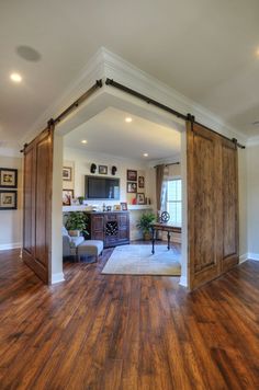 an open living room with wooden floors and sliding doors on the wall, in front of a tv