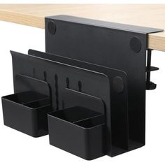 three black plastic storage containers on a wooden table