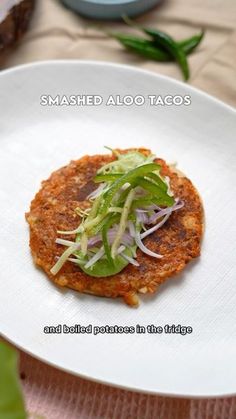 a white plate topped with food on top of a wooden table next to green leaves