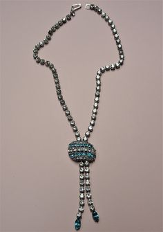 BEAUTIFUL eye catching Art Deco necklace. Lovely sparkling ice white and aqua blue glass necklace. The design is unique and very dramatic. The necklace is all hand prong set with all sparkling glittering stones,set in silver tone metal, just stunning! The necklace measures about 15 inches and the drop is about 3.25, in fabulous condition. What a dazzling beautiful vintage glass necklace perfect to give as a gift to someone very special,enjoy wearing or just adding to your collection of vintage c Light Blue Crystal Jewelry For Formal Occasions, Silver Glass Costume Jewelry Necklace, Costume Jewelry Necklaces With Sparkling Stones For Gifts, Party Turquoise Crystal Necklaces, Silver Glass Costume Jewelry, Vintage Blue Crystal Necklaces, Blue Crystal Necklace In Costume Jewelry Style, Blue Vintage Crystal Necklaces, Blue Crystal Necklace Costume Jewelry