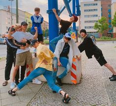 a group of young men standing next to each other in front of a blue structure