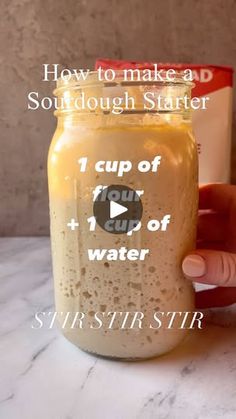 a hand holding a mason jar filled with liquid and labeled how to make a sourdough starter